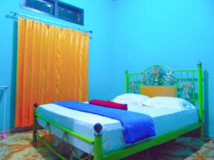 特尔纳特岛爱妮民宿的蓝色和橙色客房的一张床位