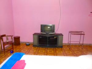 特尔纳特岛爱妮民宿的配有电视、两把椅子和一张床的房间