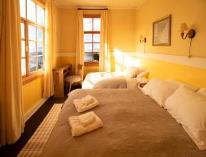 波韦尼尔Yendegaia House的两张位于酒店客房的床,配有毛巾