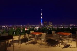 东京浅草雷门休雷克盖特酒店的享有城市天际线的夜间美景,配有桌椅