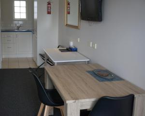 仙女港阿西莫特汽车旅馆和公寓的厨房配有木桌和两把椅子