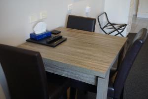 仙女港阿西莫特汽车旅馆和公寓的一张带椅子的木桌和一盒纸巾