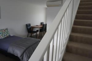 仙女港阿西莫特汽车旅馆和公寓的卧室在楼梯旁配有床