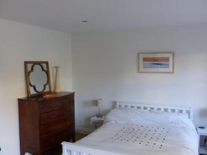 格拉斯顿伯里Littlemead - Newly renovated private studio near Glastonbury的卧室配有白色的床和木制梳妆台。
