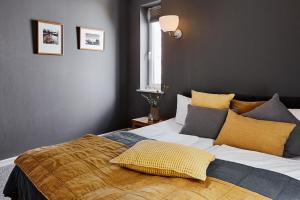 汉堡STAY Boardinghouse Flottbek的一间卧室配有一张大床,提供黄色和灰色的枕头