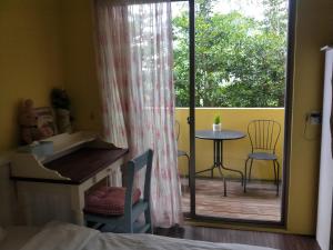 光复乡花莲甜蜜家民101宿的一间卧室设有一张桌子和椅子的阳台