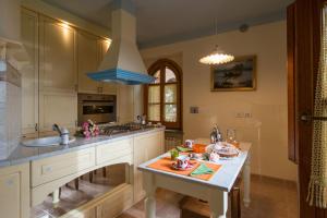 Castel Rigone圣巴托洛梅奥套房别墅的厨房配有白色橱柜、水槽和桌子