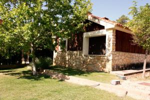 比利亚尔瓦德拉谢拉Aventura & Relax Cabañas Peña la Higuera的院子内有窗户的石头房子