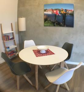 哈弗尔贝格Bilderbuchcafe - Ferien - Apartment NO 3 - Markt 7的一张桌子,上面有四把椅子和一碗