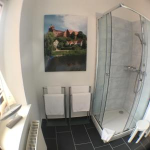 哈弗尔贝格Bilderbuchcafe - Ferien - Apartment NO 3 - Markt 7的带淋浴的浴室和2把白色椅子
