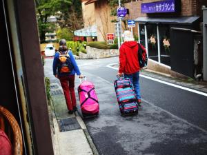 箱根隐居旅馆的两个人带着行李沿着街道走