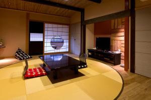 丰冈市城崎温泉 但馬屋-Tajimaya-的客厅配有桌子和电视