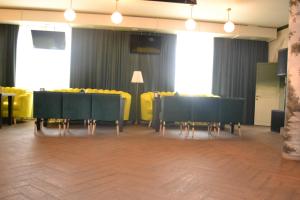 阿克托比Ayhan Hotel的用餐室配有黑色桌子和黄色椅子