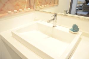 今归仁村ペンション 玉ぃ家〜的浴室设有白色水槽和镜子