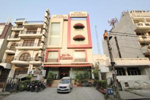 新德里Hotel Picasso Paschim Vihar Delhi - Couple Friendly Local IDs Accepted的停在大楼前的汽车