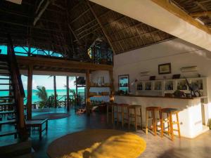 平圭Hekaya Zanzibar的一间带椅子的房间和一间享有海景的酒吧