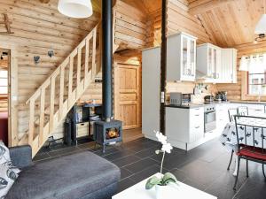 覃达达伦Two-Bedroom Holiday home in Sälen 2的小木屋内的厨房和带壁炉的客厅