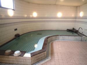 小牧市小牧城堡旅馆的一座带瓷砖墙的建筑中的大型游泳池
