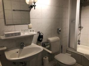 格尔斯费尔德Hotel Krone Post的一间带水槽、卫生间和镜子的浴室