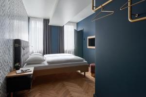 慕尼黑Hotel MIO by AMANO的一间卧室设有一张床和蓝色的墙壁