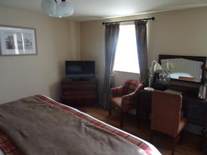 康威格鲁斯旅馆的一间卧室配有一张床、一台电视和一个窗口