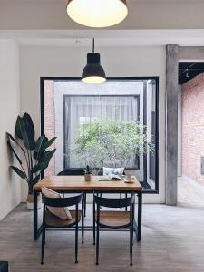 台南盖茨比公寓的一间带桌椅和窗户的用餐室