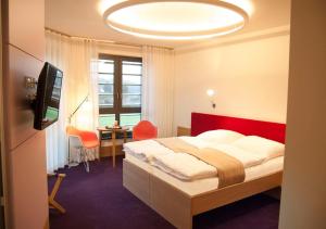 HerzbergTraumHaus im Elsterpark的一间卧室配有一张床、一张书桌和一台电视