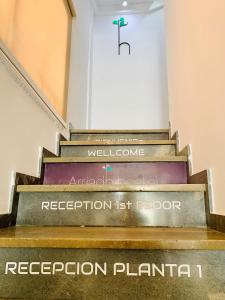 科尔多瓦阿里亚德酒店的一套楼梯,上面有读接待处计划的标志