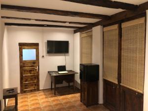 阿尔杰什河畔库尔泰亚Old Court的客房设有电视和带书桌的桌子