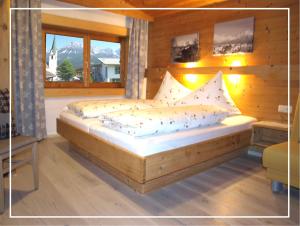 埃尔毛Alpen Chalet ELLMAU Zentrum的窗户客房内的木床