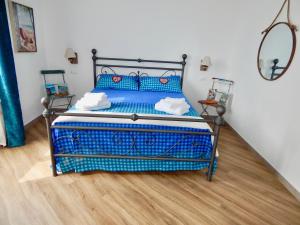 热那亚LE GIÜE的铺有木地板的客房内的一张蓝色的床