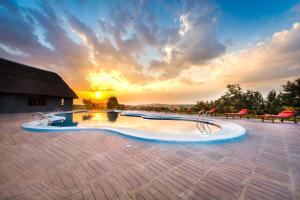 姆巴拉拉Emburara Farm Lodge的一座享有日落美景的游泳池