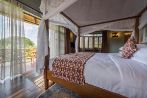 姆巴拉拉Emburara Farm Lodge的一间卧室设有一张天蓬床和一个阳台
