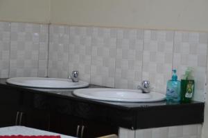 卡巴莱Jowillis Hotel的浴室设有2个水槽和2瓶肥皂