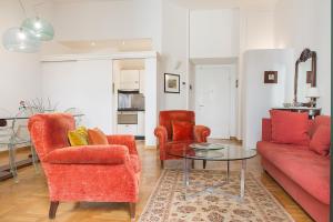 米兰Flowers' Lane的客厅配有2把红色椅子和玻璃桌