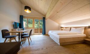 GadmenGadmer Lodge - dein Zuhause in den Bergen的一间卧室配有一张床、一张桌子和一张书桌