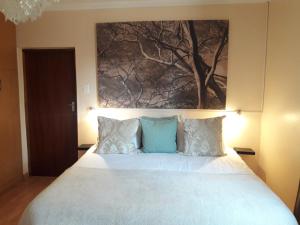 NongomaThokazi Royal Lodge的卧室配有一张大床,墙上挂有绘画作品