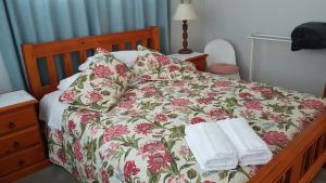 坎布里奇59 Chaucer Apartment的一张带花卉床罩的床和两张毛巾