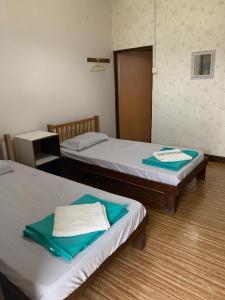 Pulau Mabul 领域潜水员水肺潜水和休闲旅馆的客房内的两张床和毛巾