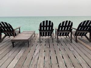 Pulau Mabul 领域潜水员水肺潜水和休闲旅馆的海洋附近的码头上摆放了三把椅子和一张野餐桌