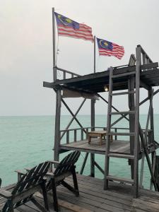 Pulau Mabul 领域潜水员水肺潜水和休闲旅馆的码头上两面美国国旗,两把椅子