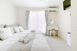 大阪Villa de Class的一间白色卧室,配有两张床和镜子