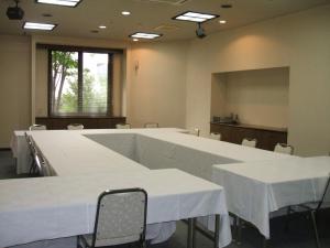 各务原市各务原路线经济型酒店的一间会议室,配有白色的桌椅和屏幕