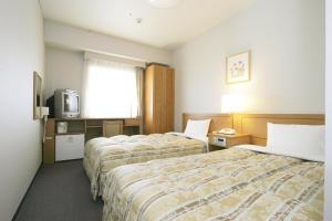 大阪大阪本町路线客栈酒店的酒店客房设有两张床和电视。