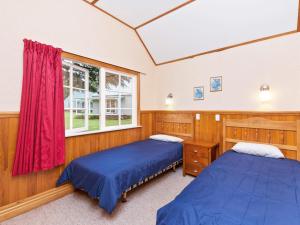 陶波Wonderful 2BR Cottage Nr Huka Falls w Aircons的一间卧室设有两张床和窗户。