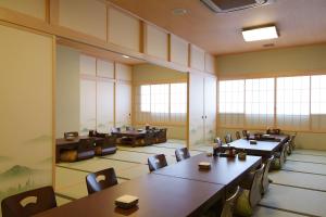 秋田格兰蒂亚路线秋田Spa度假经济型酒店的用餐室设有桌椅和窗户。