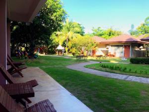 南府Villa De Bua Resort Nan的一个带长椅和走道的院子