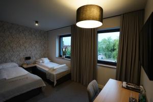 罗兹地区亚历山德鲁夫Kamienica nr 6的酒店客房设有两张床和窗户。