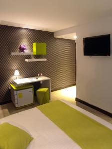 昆卡利奥尼精品酒店的一间卧室配有一张床、一张书桌和一台电视