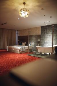 纳布卢斯Yaldiz Palace Hotel的一间卧室配有一张床、一个浴缸和一个浴缸